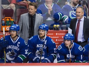 For former Canucks head coach Willie Desjardins (top right), ‘it was like I’ve got to stay out of their way — they know what they’re doing,’ he says of coaching the Sedin twins, pictured on the bench with long-time linemate Alex Burrows (right) during a January 2015 NHL game at Rogers Arena.