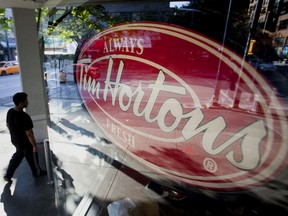 A pedestrian walks past a Tim Hortons restaurant in downtown Vancouver.