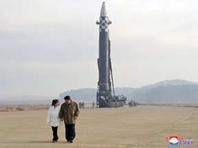 North Korean leader Kim Jong Un, along with his daughter, walks away from an intercontinental ballistic missile (ICBM) in this undated photo released on November 19, 2022 by North Korea's Korean Central News Agency (KCNA). KCNA via REUTERS