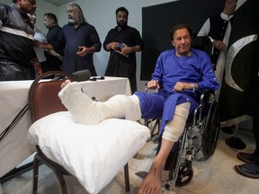 Former Pakistan's Prime Minister Imran Khan sits in a wheelchair after he was wounded following a shooting incident on a long march in Wazirabad, at the Shaukat Khanum Memorial Cancer Hospital & Research Centre in Lahore, Pakistan November 4, 2022. REUTERS/Mohsin Raza