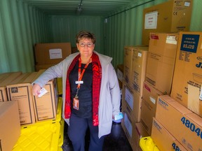 Petra Pardy, a Fraser Health executive director, standing in a steel bin full of emergency supplies.