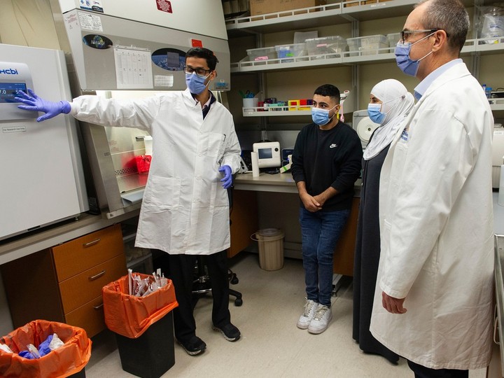  Ebrahim Aldalati, 23, (second from left) and his mother Falak Aldalati (second from right) meet with researchers Dr. Stuart Turvey (right) and Dr. Mehul Sharma (left) at the BC Children’s Hospital Research Institute in Vancouver, BC Tuesday, November 8, 2022. Ebrahim, who came to Canada at 15 as a refugee from Syria, was diagnosed with a first-in-world genetic condition, dubbed NFAT1 deficiency, by a multi-disciplinary team of doctors and researchers at the hospital. He was the first patient enrolled in the Rare Disease Discovery Hub at BC Children’s.