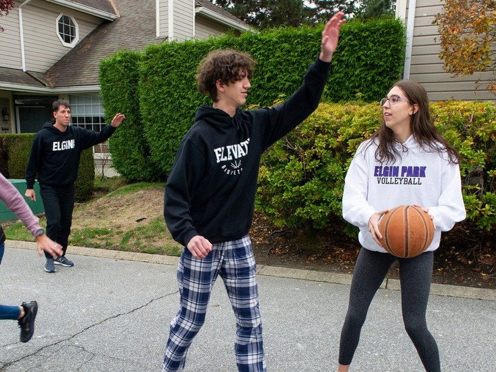  Joshua Weiss (background) with son Elijah and daughter Nadia, playing basketball outside their Surrey home.
