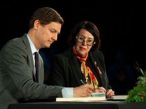 David Eby signs the official register as he is sworn in as B.C. premier by Lt.-Gov. Janet Austin.