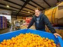 Stuart Lilley, founder of ReFeed Farms, with a container of oranges that would normally end up in a landfill.