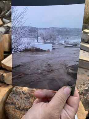 Bob Marcelet shows a photograph of the flood waters that nearly took his house away in November 2021.