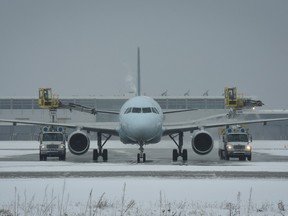 An airplane is de-iced in this handout photo from YVR. A winter storm has prompted dozens of flight cancellations at the Vancouver airport.
