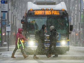 Heavy blowing snow covered commuters and pedestrians making their way across Granville Street in downtown Vancouver on Feb. 6, 2017.