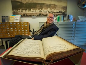 Sam Sullivan with handwritten budget minutes from 1897 inside the Vancouver Archives on Nov. 3.