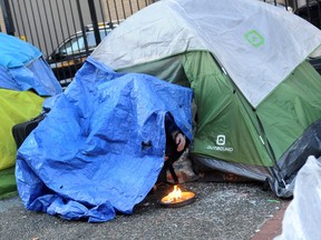 Un residente del Downtown Eastside intenta mantenerse caliente fuera de su tienda el miércoles.