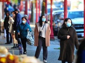 Shoppers are masked up while walking the streets of downtown Vancouver on Monday.