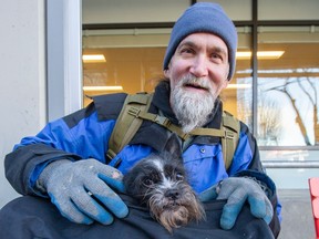 Heith Moonie, a longtime construction worker, was one of the first in line at the clinic on Sunday. Afterwards, he opened the top of a small bag to show how his eight-year old, chihuahua Shih Tzu dog named Bear was cozily tucked inside.