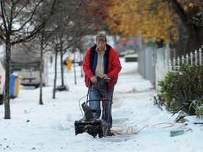 Burnaby residents clear sidewalks following the first major snow storm of the season. Temperatures are expected to rise on Wednesday.