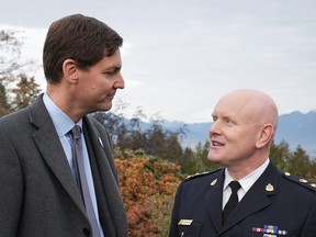 B.C. Premier David Eby, left, and Vancouver Police Chief Adam Palmer talk after Eby announced a new public safety plan in Vancouver, on Sunday.