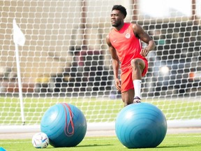 Canada's Alphonso Davies stretches during practice ahead of the World Cup in Doha, Qatar on Saturday, Nov. 19, 2022.