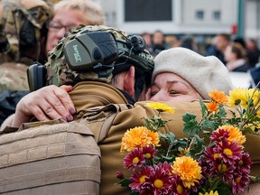 This photograph taken on November 12, 2022, shows a woman hugging a Ukrainian soldier as they celebrate the liberation of their town in Kherson, amid Russia's invasion of Ukraine.