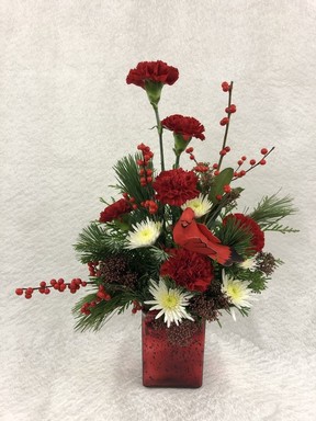 White spider mums, red carnations, fragrant greens and sprigs of deciduous holly make this a terrific, long-lasting arrangement for the holidays.
