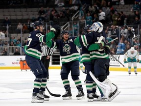 Spencer Martin of the Vancouver Canucks is congratulated by teammates after they beat the San Jose Sharks in overtime at SAP Center on Dec. 7, 2022 in San Jose, California.