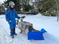 Phil Marciniak stands beside his cargo bicycle with a homemade plow for clearing bicycle lanes and sidewalks.