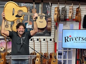 Mike Miltimore, owner of Riversong Guitars in Kamloops, is shown in this handout image, celebrating the company's P2P River Pacific guitar being named acoustic guitar of the year.