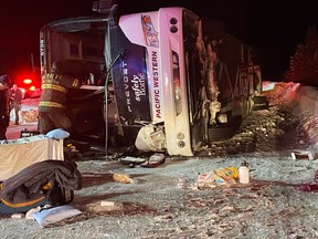 First responders look over the scene of a fatal bus crash on the Coquihalla's Okanagan Connector on Saturday, Dec. 24, 2022. Four people were killed in the crash.