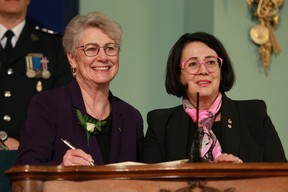 Finance Minister Katrine Conroy signs her name with Lt.- Gov. Janet Austin during the swearing-in ceremony at Government House in Victoria on Dec. 7, 2022.
