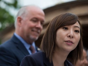 Former B.C. minister of state for child care Katrina Chen speaks as then-premier John Horgan listens during an announcement in Vancouver, on Thursday July 4, 2019. Chen says she took herself out of contention for a new ministerial position in order to deal with "long-standing trauma" suffered as a result of gender-based violence.
