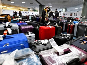Passengers search for luggage following flight cancellations and delays caused by a winter storm at Vancouver International Airport on Dec. 22, 2022. REUTERS/Jennifer Gauthier