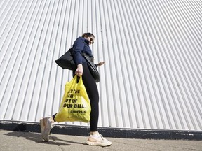 A person leaves a Toronto supermarket with groceries on Wednesday, Oct. 5, 2022. The House of Commons committee looking at food price inflation will hear from executives at some of Canada's biggest grocers on Monday. Executives from Loblaw Companies Ltd. and Empire Co. Ltd. as well as other experts are expected to face questions from the committee.