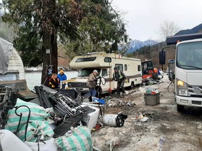 Volunteers clean up an abandoned encampment near the Chilliwack River Thursday. There are at least nine homeless camps in a six-kilometre stretch of the Chilliwack River Valley.