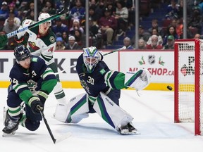 Vancouver Canucks goalie Spencer Martin (30) allows a goal to Minnesota Wild's Matt Boldy, not seen, as Vancouver's Ethan Bear (74) defends during the first period of an NHL hockey game in Vancouver, on Saturday, December 10, 2022.