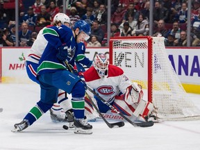 Montreal Canadiens goalie Sam Montembeault (35) looks on as forward Christian Dvorak (28) battles for the rebound with Vancouver Canucks forward Nils Hoglander (21) in the first period at Rogers Arena.