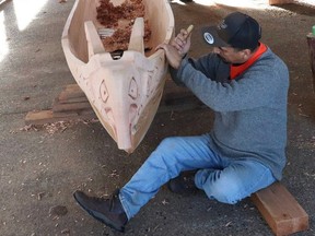 Hipolite Williams carves the Thunderbird as the bow of the new canoe in Port Alberni.