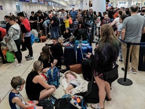 Passengers from Sunwing airlines line up for check-in at Cancun International Airport after many flights to Canada have been canceled because of the severe winter weather conditions in various parts of the country, in Cancun, Mexico December 27, 2022.