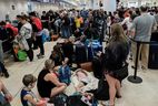 Sunwing Airlines passengers line up to check in at the Cancun International Airport after many flights to Canada have been canceled due to severe winter weather conditions in various parts of the country, in Cancun, Mexico on December 27, 2022. .