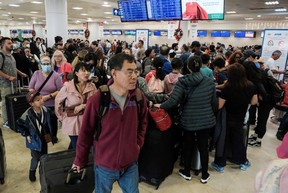 Passengers from Sunwing airlines line up for check-in at Cancun International Airport after many flights to Canada have been canceled because of the severe winter weather conditions in various parts of the country, in Cancun, Mexico December 27, 2022.