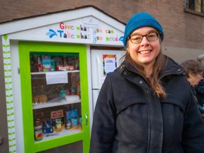 Volunteer Mona Grenier helps stock a new community pantry and refrigerator outside the Kitsilano Neighborhood House.  Pantries are a place where donors can drop off food and patrons can grab what they need, 24 hours a day, no questions asked.
