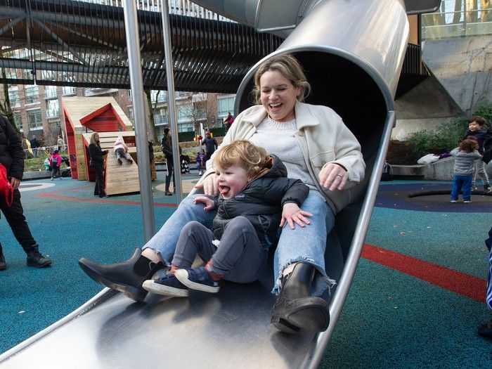  leo fumano, 2, emerges from a covered slide with mom megan fumano at sθәqәlxenәm ts’exwts’áxwi7 in vancouver.
