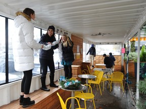 Volunteers from Alcuin College prepare Christmas decorations for the City of North Vancouver’s Open Streets program on Lonsdale Avenue. They’re inside a city-sponsored shipping container, which has been adapted into a public space and used for Remembrance Day, Halloween and other events.
