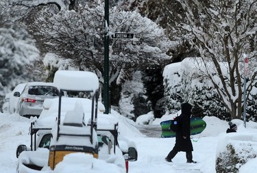 Vancouver residents clear sidewalks outside their homes on Dec. 20. 2022.