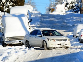 Cars navigate uncleared streets following the recent snowfall in Vancouver, BC., on Dec. 21, 2022.