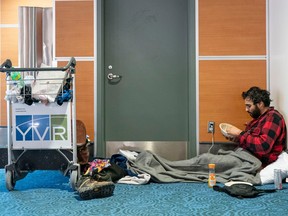 Paul-Hugo Mena-Ouimet has lunch in a corner of Vancouver International Airport while waiting for his flight to Montreal on Dec. 23, 2022.
