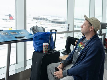 Alexander Salasse stares out a window while waiting at Vancouver International Airport for a flight home to Quebec on Dec. 23, 2022.