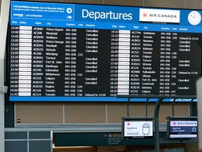Delays and cancelled flights fill the Air Canada departures board at Vancouver International Airport on Dec. 23, 2022.