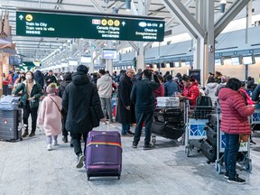 Passengers wait in line at the international departures hall hoping to check in at Vancouver International Airport as delays and cancelled flights cause havoc for holiday travellers on Dec. 23, 2022.