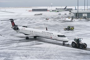 An Air Canada jet is towed to a gate at Vancouver International Airport on Dec. 23, 2022.