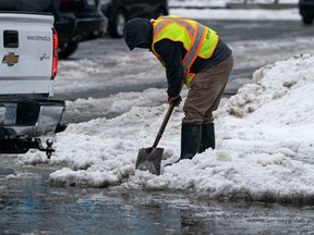City crews in Metro Vancouver work to clear storm drains from snow earlier in the week before freezing rain fell Friday, Dec. 23, 2022, making way for a downpour on Dec. 24.