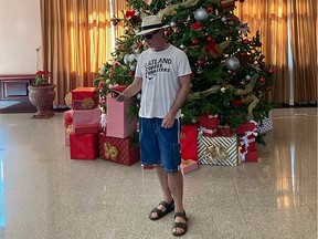 Handout photo of Shawn Conner checking his phone for airline updates in front of a Christmas tree in the lobby the Hotel Riu Palace Pacifico in Puerto Vallarta, Mexico.