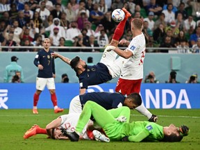 France's Olivier Giroud scores a disallowed goal as Poland's Wojciech Szczesny reacts after sustaining an injury.
