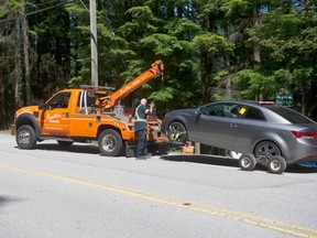 Pay parking has helped alleviate some parking problems at popular Metro Vancouver regional parks. In a file photo from 2020, a tow truck hauls away a vehicle parked in front of a no parking sign along Bedwell Bay Road in Port Moody near təmtəmíxʷtən/Belcarra Regional Park.